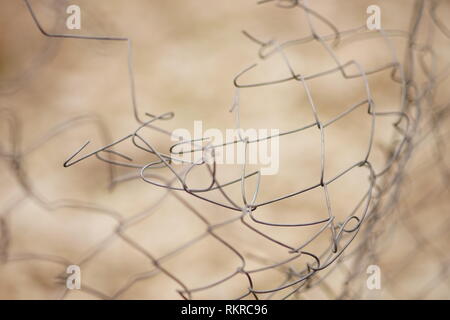 Torn barbed wire bent. Damaged fence. Macro photo. Selective focus Stock Photo