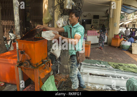 Breaking ice blocks with machine on the street in Phnom Penh Stock Photo