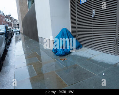 Homeless Person Under Sleeping Bag Stock Photo
