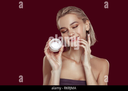 Blonde-haired model with nice makeup promoting cream Stock Photo