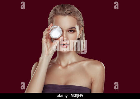 Professional model with little pack of cream posing with it Stock Photo