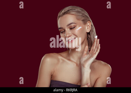 Young appealing model laughing while promoting cosmetics brand Stock Photo