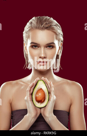 Slim professional model showing avocado posing for food magazine Stock Photo