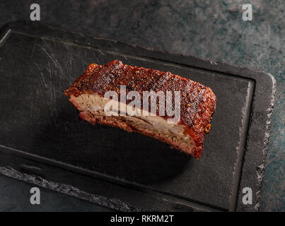 Roasted barbecue pork ribs on black slate cutting board Stock Photo