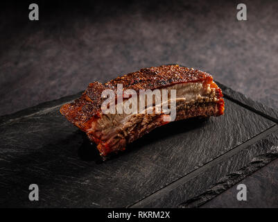 Grilled barbecue pork ribs on a black slate cutting board Stock Photo