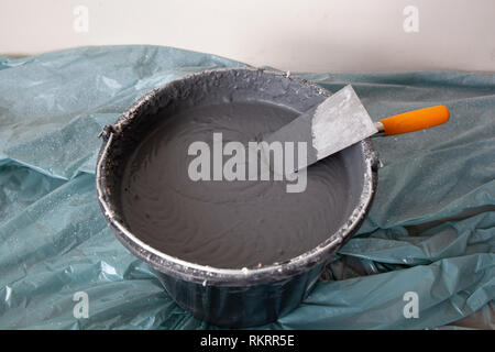 Decorative cement plaster and a trowel in a construction bucket ready for plastering Stock Photo