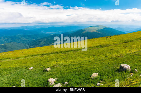 summer mountain scenery. rocks on the grassy meadow. distant ridge beneath a cloudy sky. beautiful vivid landscape of carpathian mountain. Stock Photo