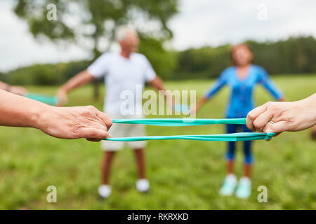Senior group doing physiotherapy exercise with stretch band in circle Stock Photo