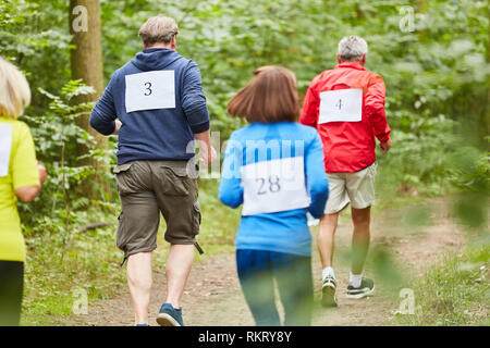 Vital seniors in running training for endurance together in nature Stock Photo