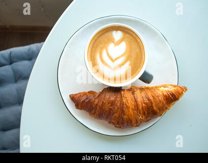 Croissant with jam, butter and a cup of coffee. Stock Photo