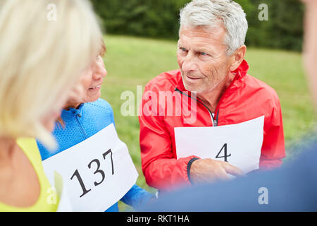 Seniors discuss with a treasure hunt or geocaching competition Stock Photo