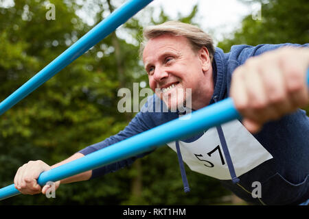 Senior man doing push-up exercise on a gym equipment on the trim you path Stock Photo