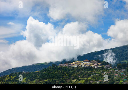 The ancient Buddhist monastery set against the Himalayas with heavy clouds and surrounded by the town at Tawang, Arunachal Pradesh, India. Stock Photo