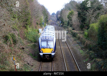 The Belfast to Bangor railway line at Cultra, County Down, Northern Ireland. The Class 4000 is a type of diesel multiple unit in service with NI Railways. Although the trains are externally similar to the C3K fleet, internally they have significant differences. Each three-car train has a seating capacity of 212,[8] with fewer table bays and extra standing room.[6] They have one toilet compared to the C3K's two.[8] They have a new traction system, with an MTU 390kW engine providing power to both the traction motors and auxiliary generators. With a train being four tonnes lighter than a C3K unit Stock Photo