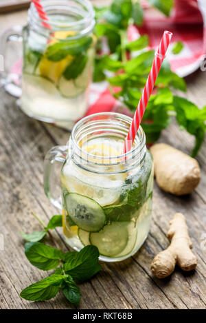 Healthy eating lifestyle concept. Homemade detox lemonade with cucumber, ginger and mint in retro mason jar glass on wooden table. Summer refreshment  Stock Photo
