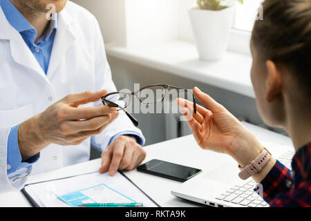 optician gives new glasses to a patient Stock Photo