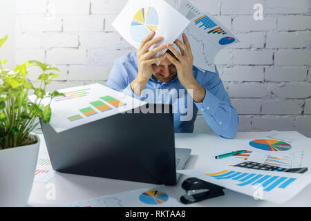 desperate overworked businessman doing paperwork in office Stock Photo
