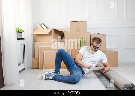 Handsome young man moving into his new home Stock Photo