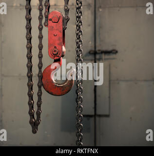 handle metallic chain with red hook in technical room Stock Photo
