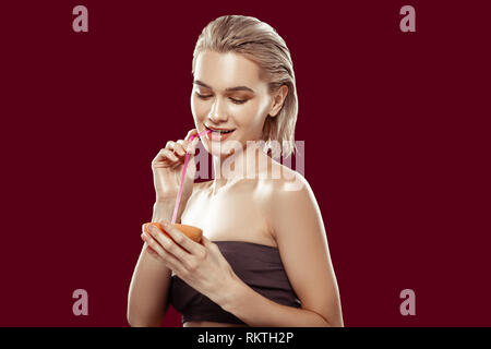Blonde-haired slim model sipping some grapefruit juice Stock Photo