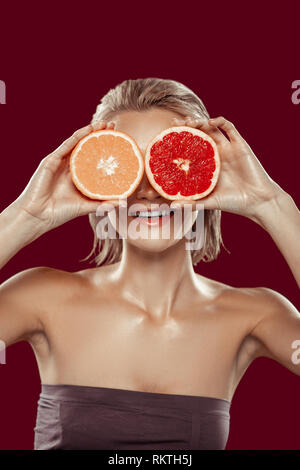 Model with short bob cut posing with orange and grapefruit Stock Photo