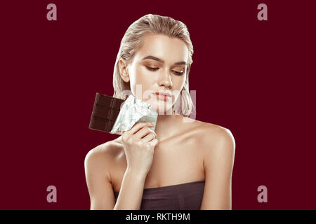 Model taking part in healthy diet campaign holding chocolate Stock Photo
