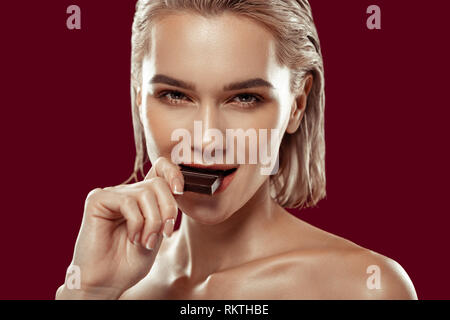 Close up of beautiful dark-eyed woman eating some chocolate Stock Photo