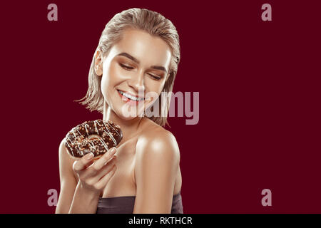 Young model laughing while posing with sweet doughnut Stock Photo