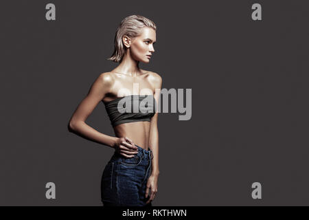 Slim blonde-haired model with bob cut wearing nice jeans Stock Photo