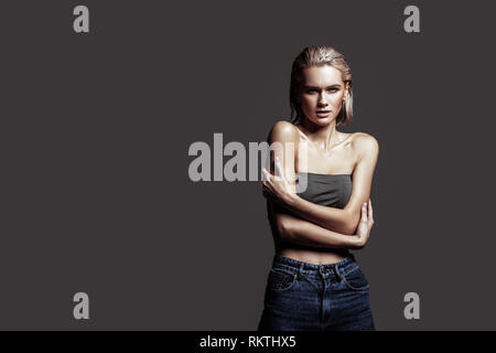 Blonde-haired model touching her shoulder while posing Stock Photo