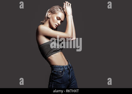 Blonde-haired model dancing while posing for photographer Stock Photo