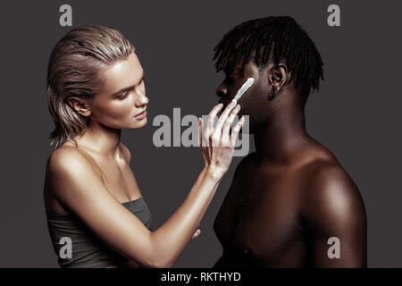 Two models using face cream while promoting cosmetics Stock Photo