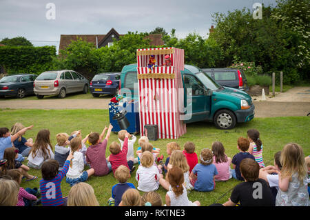 Children enjoy the traditional Punch & Judy Show at Great Milton Fete, Oxfordshire. Stock Photo