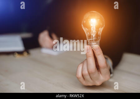 Hand of woman holding a light bulb for accounting and creative. New ideas, innovation and inspiration concepts Stock Photo