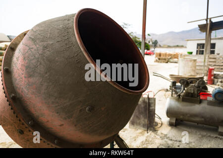 Mobile electric cement mixer and wheelbarrow with cement mortar Stock Photo