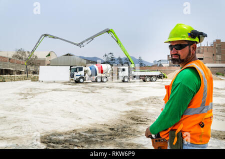 Concrete pump operator with remote control for boom pump truck at construction site. Stock Photo