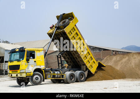 Ten yard dump truck delivering a load of dirt for a fill project at a new commercial development construction project Stock Photo