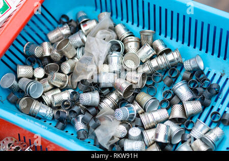 Silver metal thimbles in a blue basket. Stock Photo