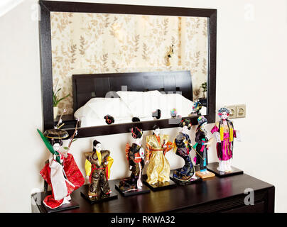 Japanese dolls near mirror in bedroom interior Stock Photo