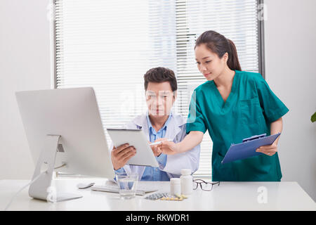 Group of doctors and nurses examining medical report of patient. Team of doctors working together on patients file at hospital. Stock Photo