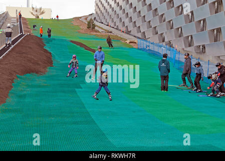 Copenhagen, Denmark. February 12th 2019. CopenHill, the artificial ski slope on top of the new waste-to-energy plant on Amager in Copenhagen on the first of two days' test skiing during spring half term of the Danish schools. The energy plant is working, but the ski slope and other recreational facilities will be ready to open very soon. The two days' test skiing will only take place on the lower end of the slope, but seems to be a success for all ages. The plant and ski slope is designed by architect Bjarke Ingels BIG. Credit: Niels Quist/Alamy Live News Stock Photo