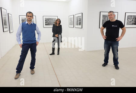 Reggio Emilia, Italy. 09th Feb, 2019. The directors of the project called 'Binario 49', Khadija Lamami, Claudio Melioli (r) and Alessandro Patroncini are in the photo exhibition they initiated with the works of Sebastião Salgado. The Brazilian photographer 'donated' an exhibition to the infamous quarter in Italy in order to fight xenophobia. He lent them 100 of his works for the show 'Africa'. Credit: Alvise Armellini/dpa/Alamy Live News Stock Photo