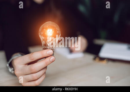 Hand of woman holding a light bulb for accounting and creative. Idea saving energy and accounting finance Stock Photo