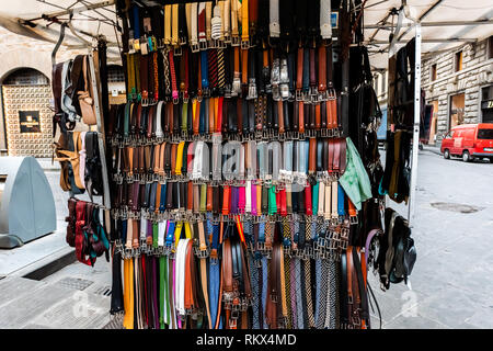 Florence, Italy - August 31, 2018: Closeup pattern of many belts leather colorful vibrant colors hanging on display in shopping street market in Firen Stock Photo