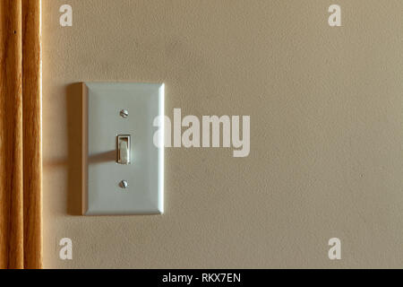 An old North American light switch on a wall near a doorway Stock Photo