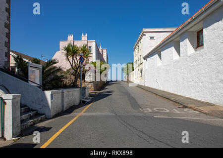 Looking up Les Rocquettes road toward the Butes car Park in St Anne's on Alderney, Channel Islands. Stock Photo