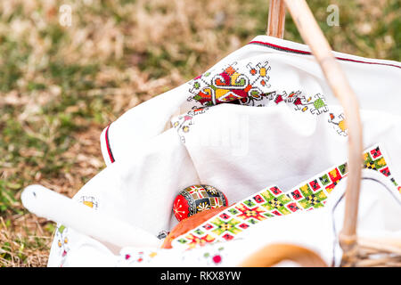 Eggs and Kulich Russian Ukrainian Orthodox Easter blessing food straw basket on grass ground outside at church with candle nobody closeup Stock Photo