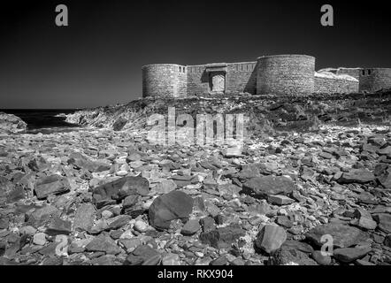 An Infrared monochrome image of Fort Houmet Herbe and causeway on an offshore island on the coast of Aldernney, Channel Islands. Stock Photo