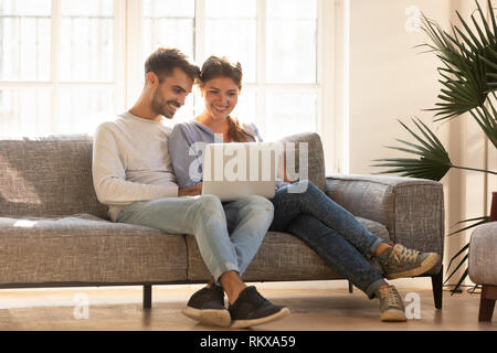 Millennial happy couple using laptop doing online shopping, ecommerce Stock Photo