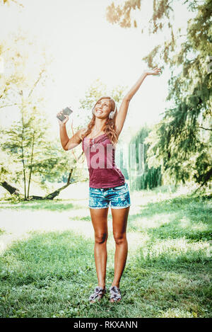 Young woman relaxes with headphones and is dancing listening her ...